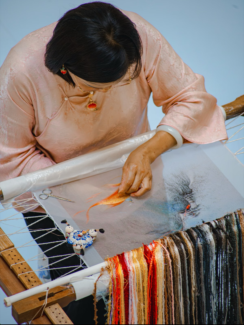 A Suzhou embroidery master at work on a silk goldfish